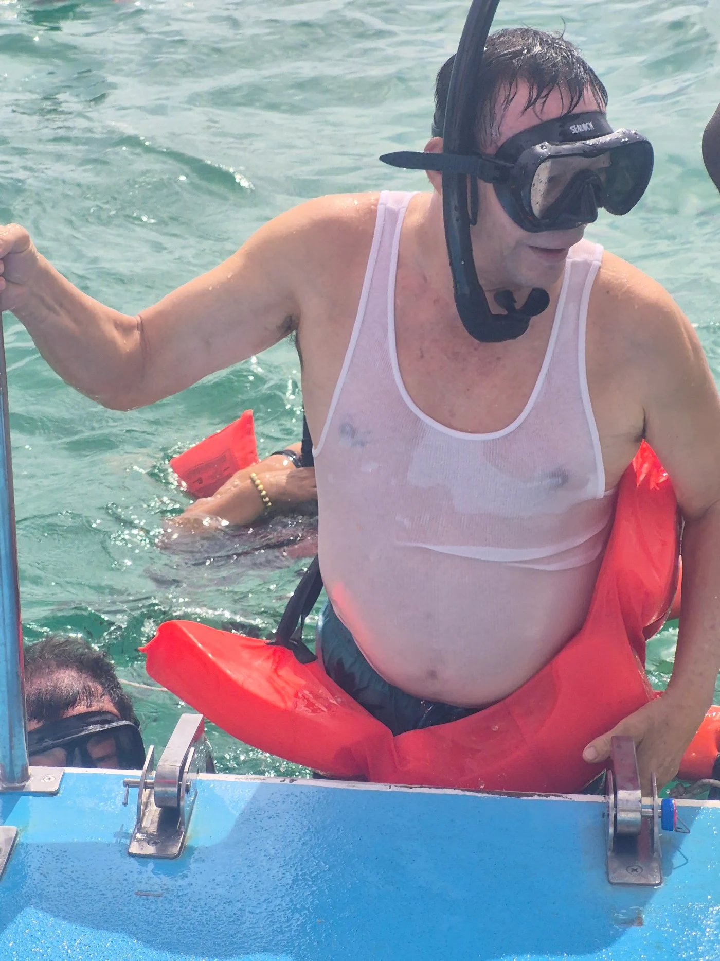 A guest wearing snorkeling gear at the boat ladder