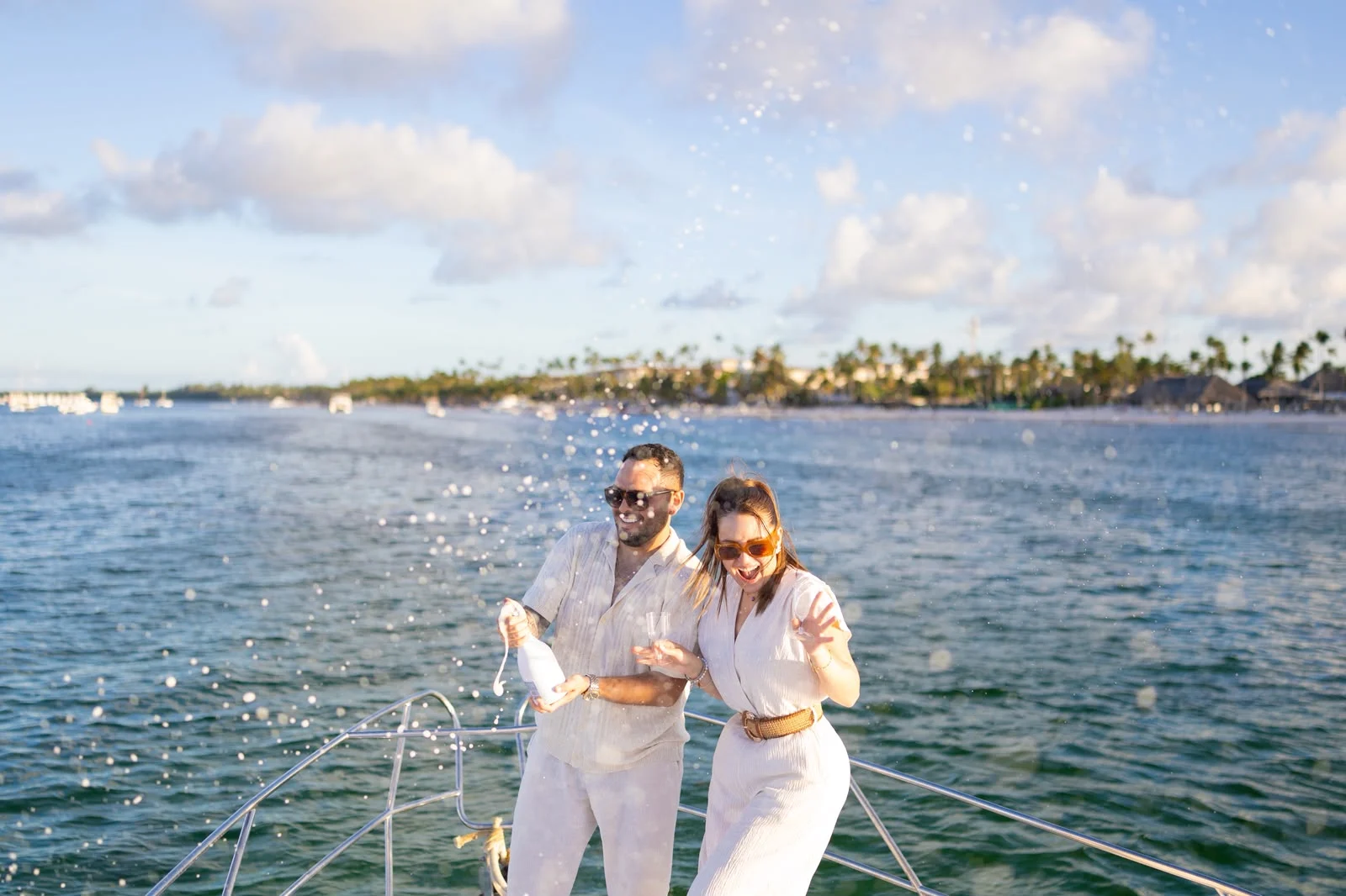 Couple celebrating with champagne on the bow of a yacht